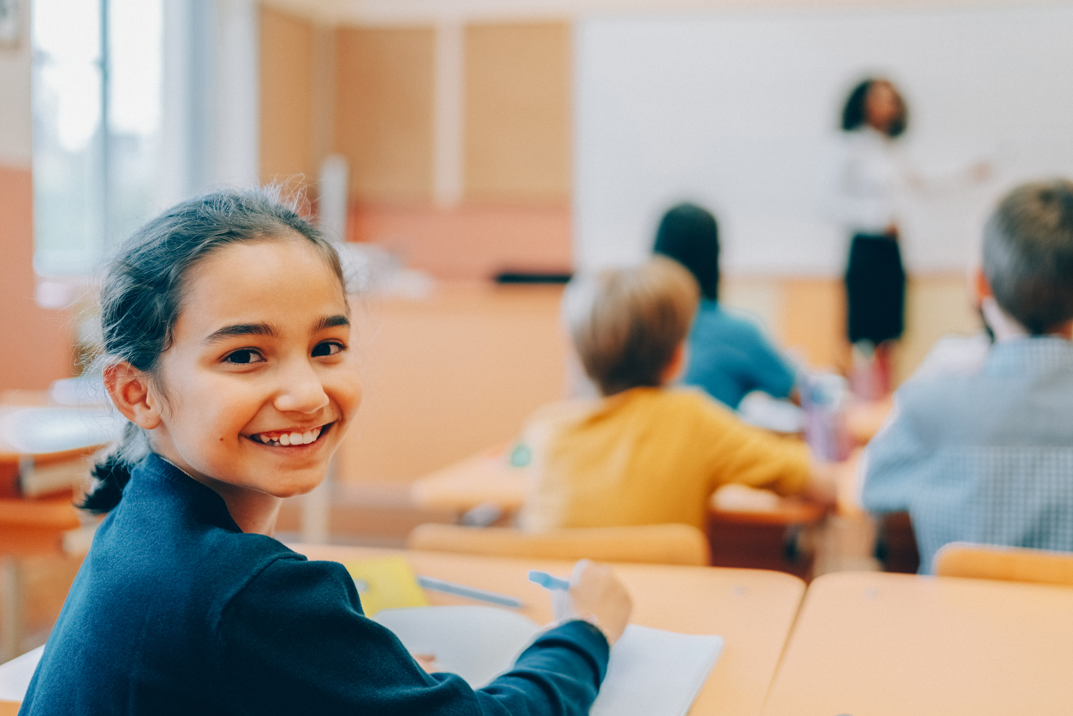 Smiling child at desk in classroom